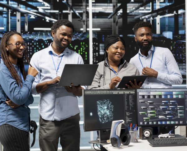 Cheerful data center experts working together, using deep learning algorithms and node trees to analyze datasets. Jolly server farm teamworking colleagues using AI to recognize facility data patterns